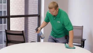 A man details a table in an office conference room